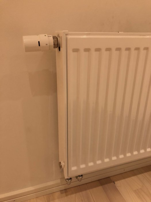 Vit radiator med avtagen termostat som visar piggen.