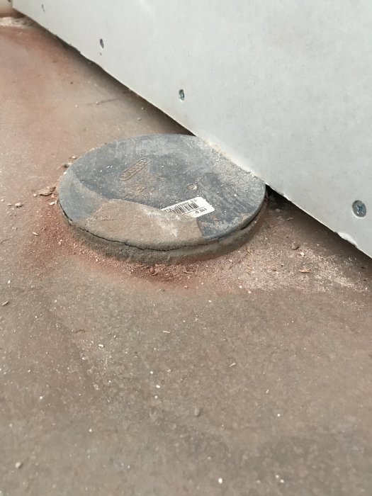 Avloppsanslutning för vägghängd toalett på betonggolv med OSB och gipsvägg i ett pågående badrumsbygge.