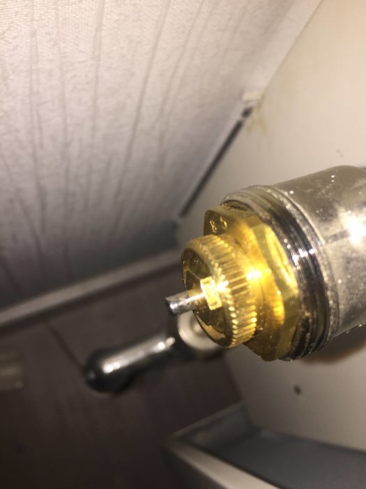 Radiatorventil med synlig sexkantmutter och sprint, där muttern ligger utanför den räfflade delen.