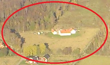 Flygbild av en äng omgiven av stengärdsgårdar med en byggnad vid kanten, markerad med röd cirkel.