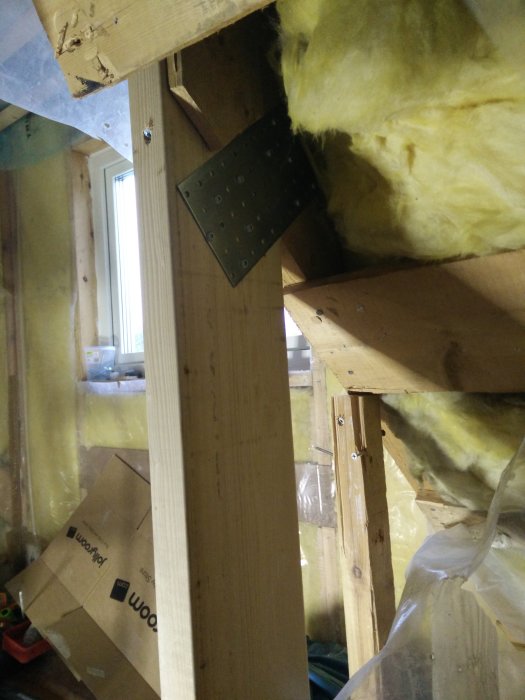 Nytt stödben med metallplatta som stagats upp mellan golvreglar i en byggkonstruktion.