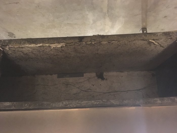 Bild av en ventilationstrumma med äldre isoleringsmaterial märkt "381 isol", oklart om det är asbest.