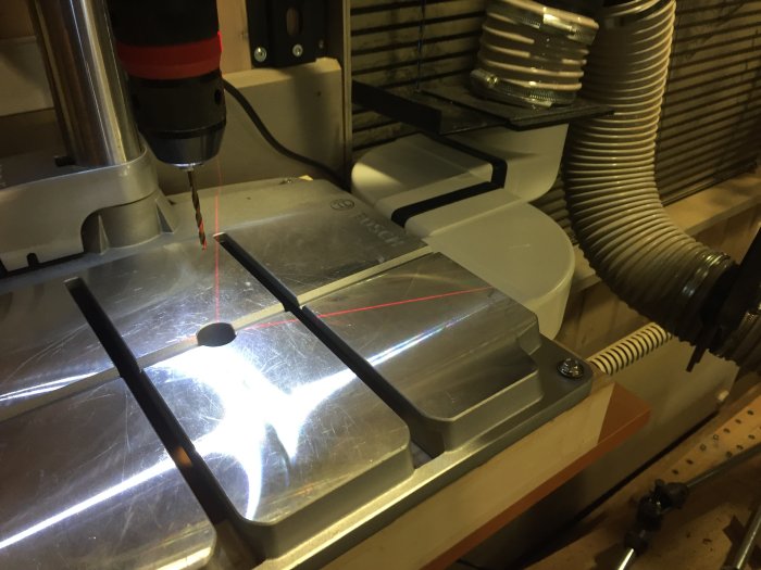 Borrspånsug kopplad till en bänkborrmaskin, precision med laser, organiserad borrhållare.