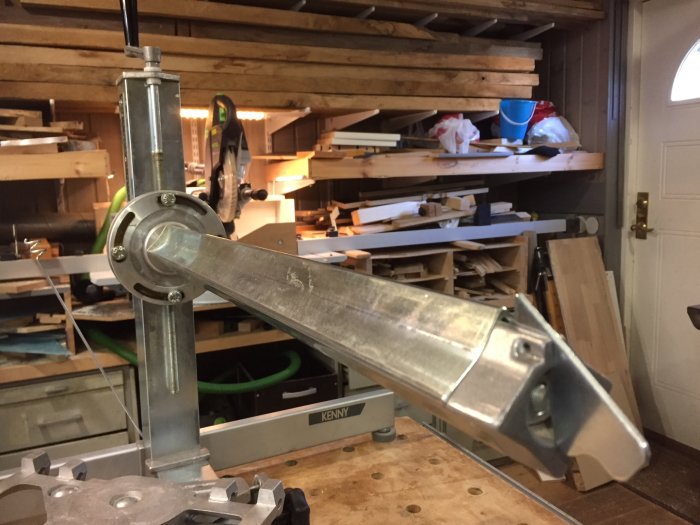 Sågstativ med höj- och sänkbar arm, kullagrad vagn och kvadratisk arm i en verkstadsmiljö.