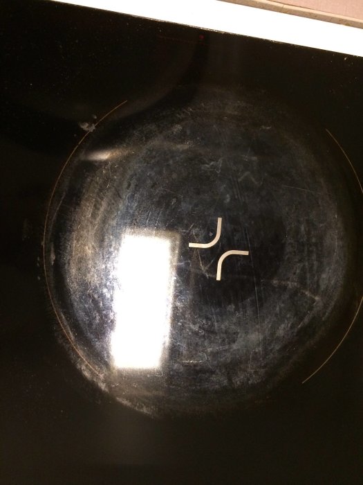 Repig och smutsig svart induktionshäll med synliga skador och slitage.