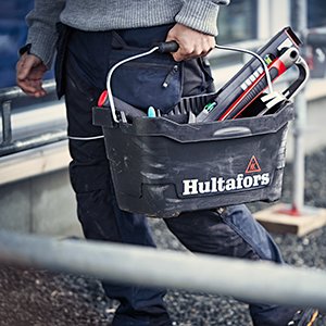 Person håller i en Hultafors verktygsväska fylld med verktyg.