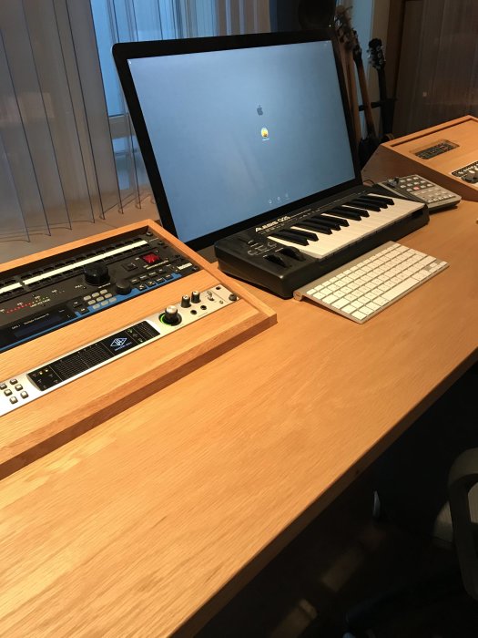 Anpassad studiomöbel med tangentbord, mixer, skärm och en utfällbar mugghållare med CD-skivor.