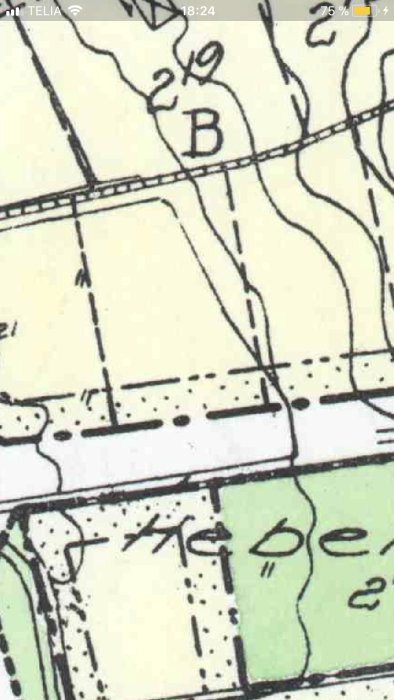 Utsnitt av en byggplan som visar tomtmark med angiven prickad mark nära en gata och noteringar.