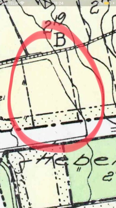 Fastighetskarta med en markerad tomt nära gatan och intilliggande garage en meter från gränsen.