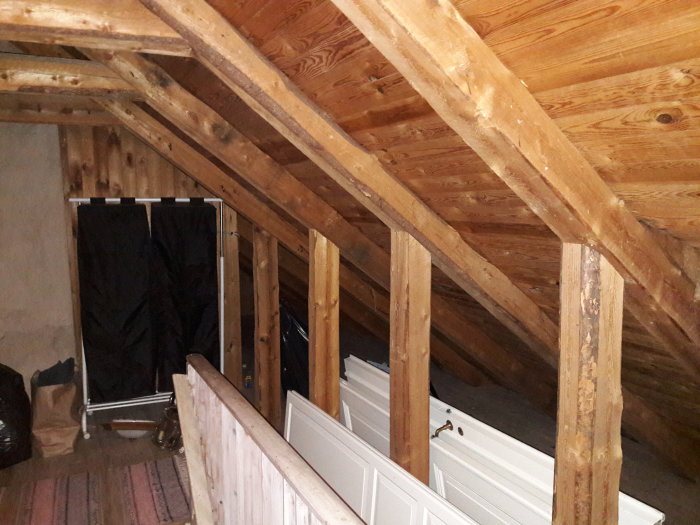 Träbjälkar och stödbjälkar på en vind med synliga dimensioner och avstånd, intill badkar och gardin.