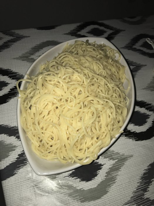 En skål med kokad spaghetti som har kylningsolja på för att förhindra klumpning.