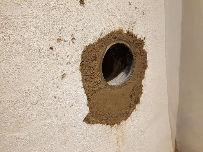 Ny murad öppning i väggen utan tillgång till källaren, omgiven av ojämn betong och puts.