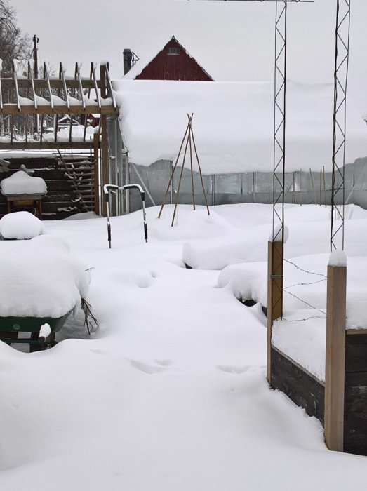 Växthus täckt av tjocka snölager visande isoleringens effektivitet under vintern.