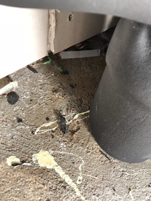 Fuktig hörna med limrester och smuts under byggprocessen.