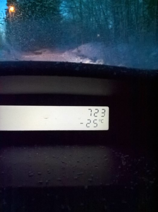 Bild från bilens instrumentbräda som visar klockslag 7:23 och kall temperatur på -25 grader Celsius med snöig landsväg i bakgrunden.