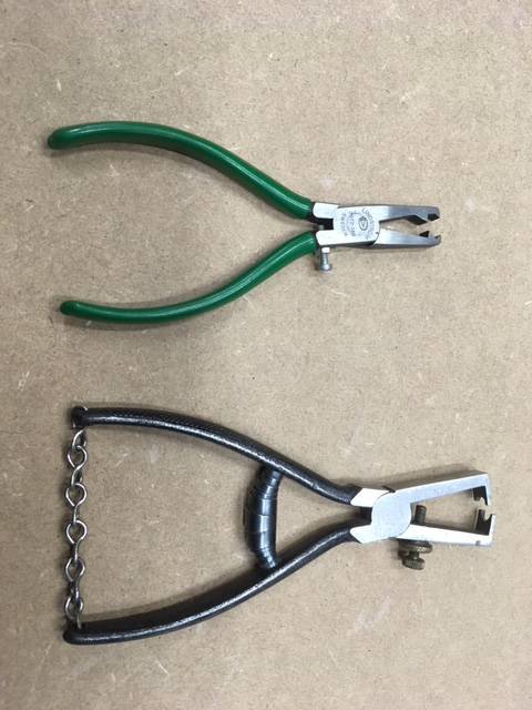 Gröna Knipex kombitång överst och svart häfthammare med kedja under.