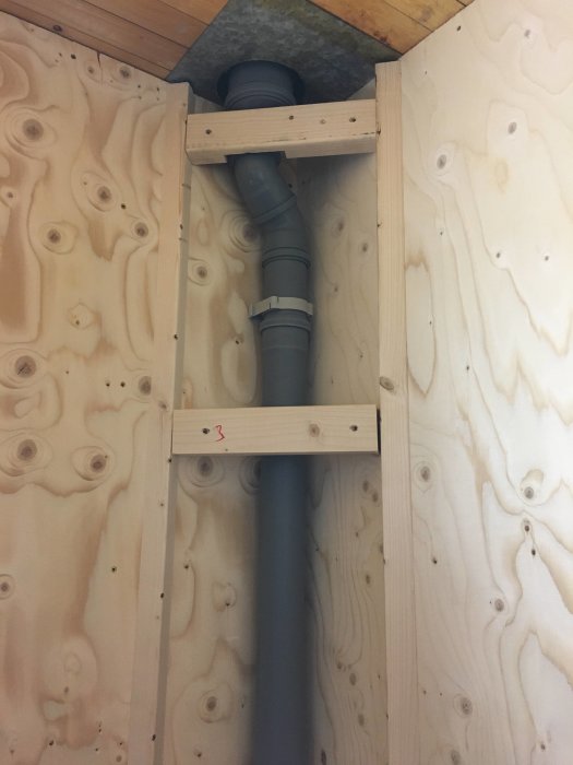 Avloppsventilation inbyggd i 45 graders hörn med 12mm plywoodvägg och träreglar.