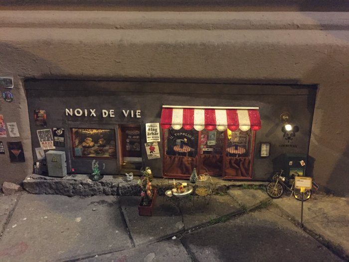 Miniatyrbyggprojekt av Anonymouse med en butik och restaurang för möss på en trottoar.