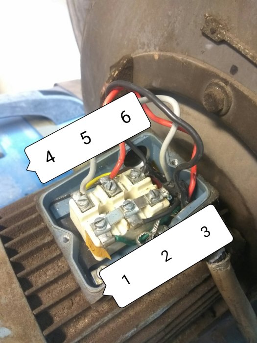 Elektrisk anslutningsplint inuti en maskin med numrerade kablar och kontakter.