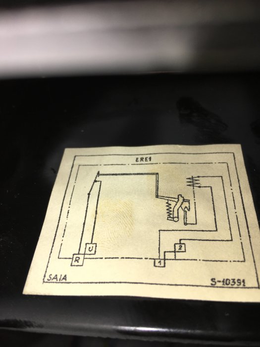 Bild på ett gulnat elschema papper på insidan av en kåpa, visar ledningar och komponenter.