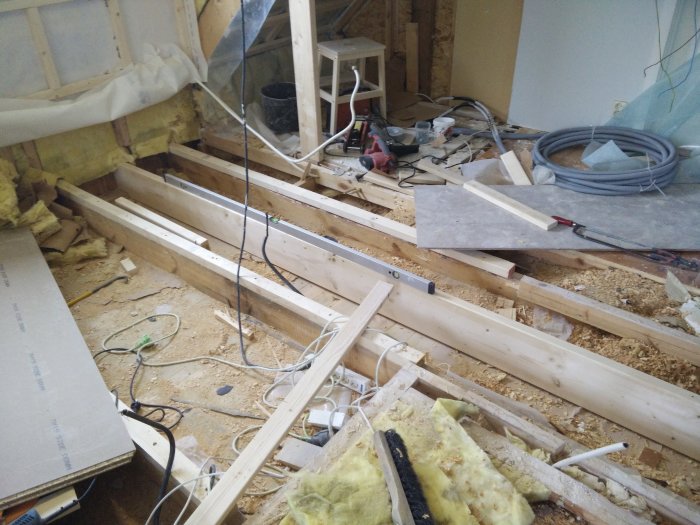 Rakentaminen ja remontointi: lattian tukipalkkien vahvistustyö, johon kuuluu uusi puu, työkalut ja rakennusmateriaalit työmaalla.