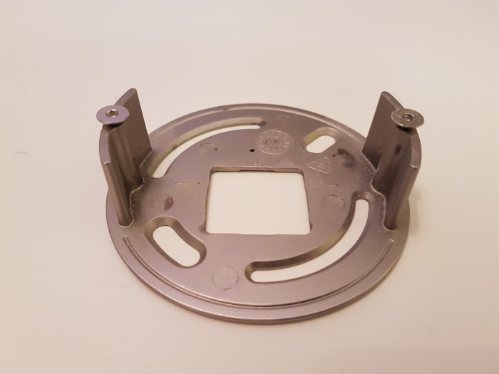 Metallhållare avsedd för montage i tak, med fästvinklar och utskärningar.