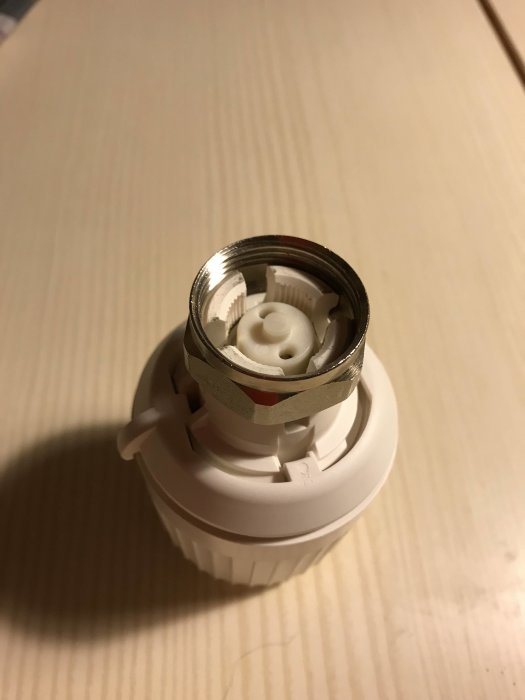 Närbild på öppen termostat och adapter med synlig utstående pigg, problem vid montering beskrivs.