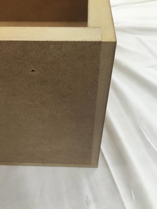 Detaljbild av en MDF-träkonstruktion med en limmad fog och dyckert.