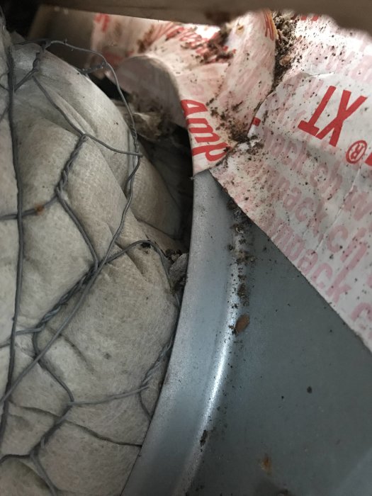 Vattenskada och sprucken takpanna med synlig glipa och felpaketering på en byggnad.