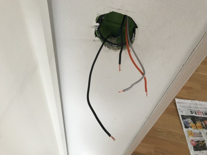 Elektrisk installation med oskarvade kablar framdragna ur en vägg, redo för anslutning till en strömbrytare.