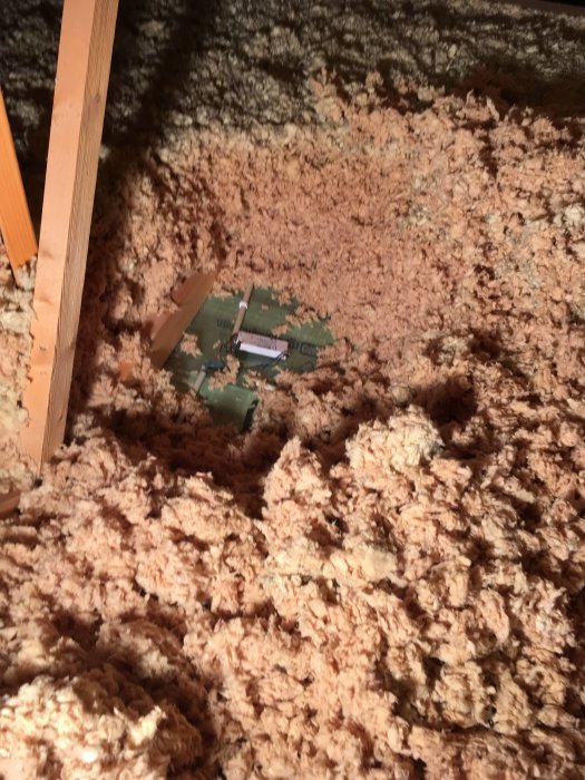 Rosafärgad isolering på vinden över badrummet, tecken på missfärgning.