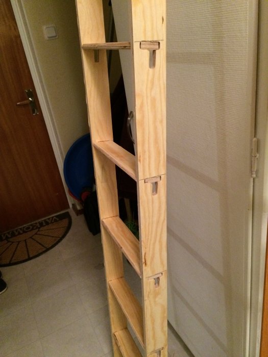 Handgjord smal stege av furu möbelplywood i ett trångt rum.