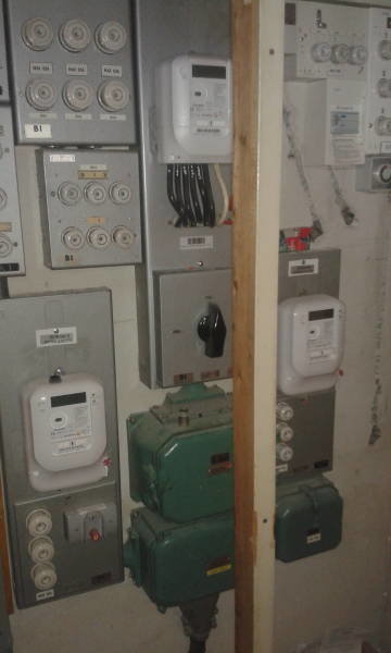 Bild på en äldre elektrisk central med många mätare, kopplingslådor och kablar före en ombyggnad.