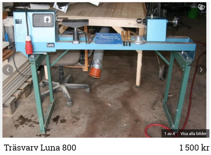 Träsvarv Luna 800 på grönt stativ i ett garage med dammsugarslang kopplad.
