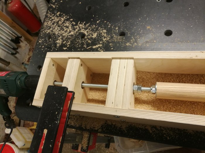 Hemmagjord träbearbetningsanordning för att svarva och fräsa rundstavar i arbetsbänk med borrmaskin.