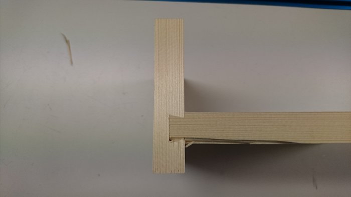 Träbit med sinkat spår och testbit som visar passformen, arbete på en snickeriprojekt.