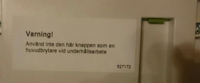 Varningslapp på elmätare som instruerar att inte använda knappen som huvudbrytare under underhåll.