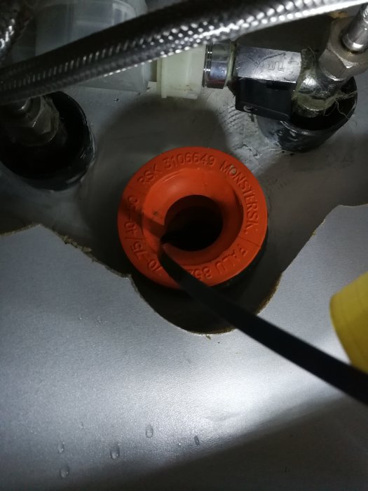 Närbild på avloppsanordning under diskbänk med synliga rör och avloppsslang.