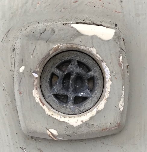 Närbild av en tappningsnyckel för radiator i färgsliten miljö.