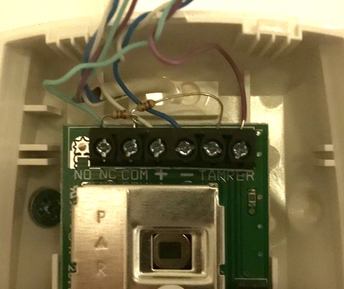 Elkopplingskort med trådar, motstånd och terminaler inom ett elektroniskt system under installation.