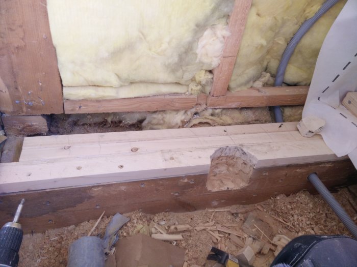 Lattialankku kylpyhuoneen rakenteissa eristeen ja kaapeleiden kanssa. Edistynyt vahvistus näkyy, puulastut alhaalla.