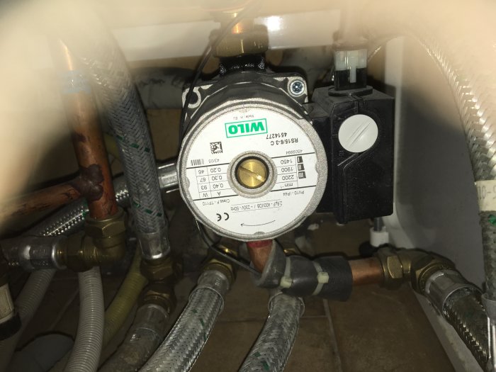 Cirkulationspump och kopparledningar installerade i ett värmesystem.