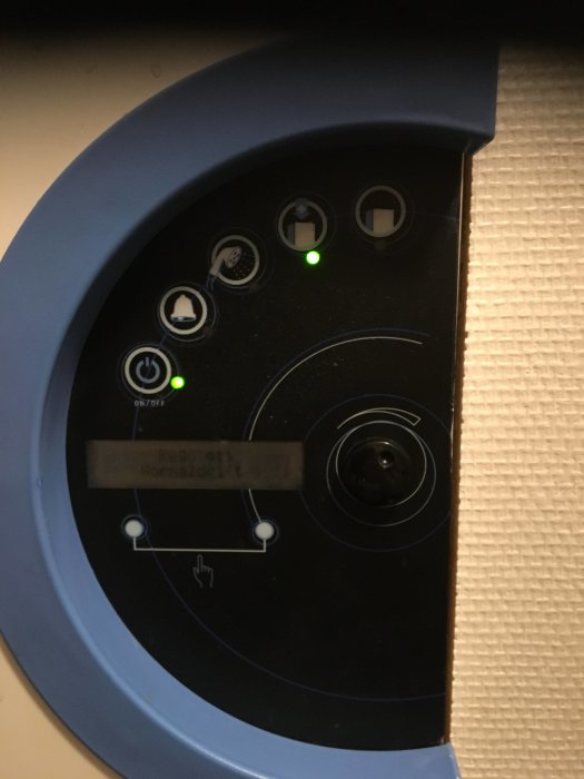 Kontrollpanel på en enhet med gröna indikatorljus och en display som visar texten "Restid 91 MinSlut8:27".