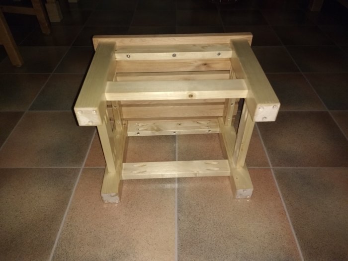 Hemmagjord trästegpall på ett kakelgolv, ihopfogad med pocket hole-teknik och behandlad med Danish Oil.