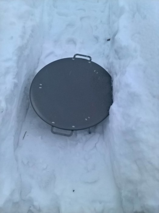 Muurikka stekhäll på 58cm placerad i snöskottad odlingslåda, redo för matlagning utomhus.