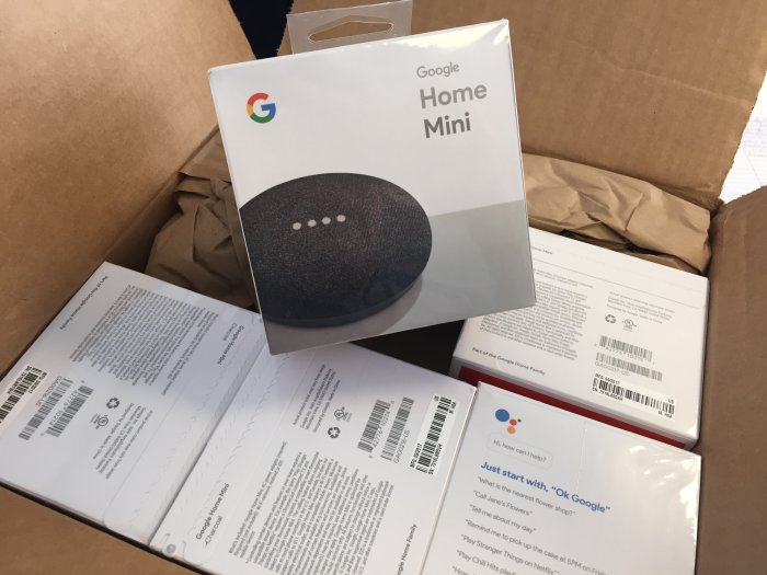 Förpackningar av Google Home Mini högtalare packas upp ur en kartong.