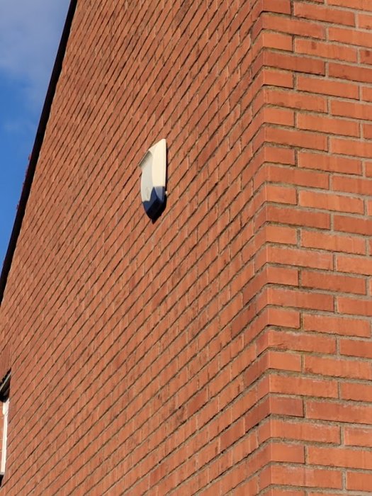 En låda på en tegelväggs yttervägg som blinkar med ett litet ljus.