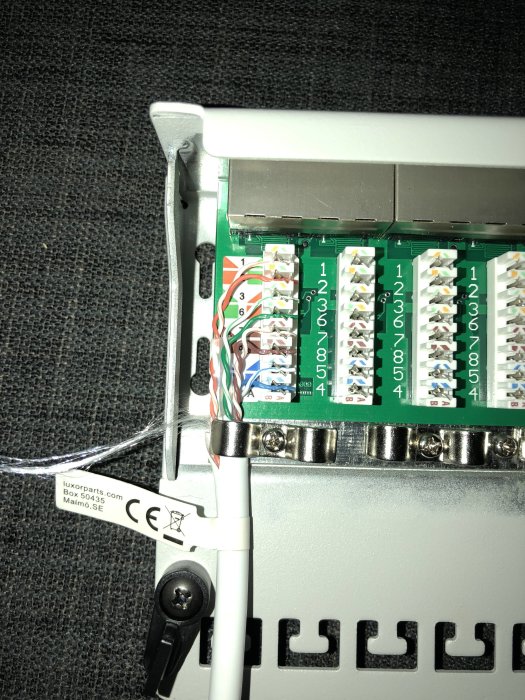 Patchpanel med en ansluten nätverkskabel och trådernas färger korrekt anordnade enligt standard.