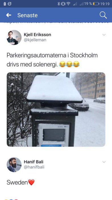 En parkeringsautomat täckt av snö visar ironi om solenergibaserad utrustning i snöigt klimat.