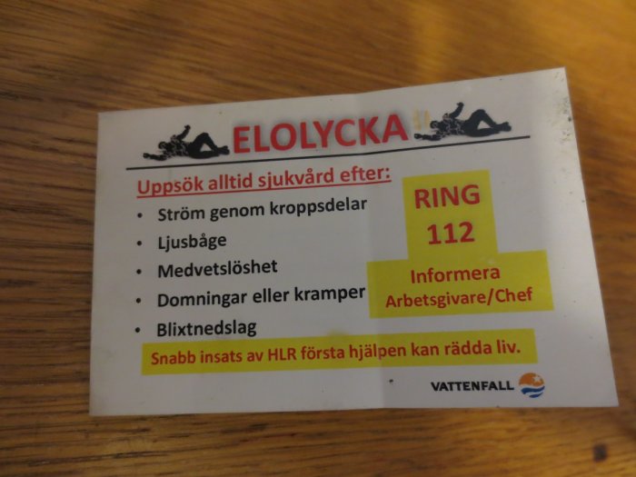 Fyrasidigt kontokortsformat häfte med instruktioner för elolycka, inklusive symboler och steg för nödsituationer.